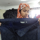 Jeans piled high behind a garment worker. Large quantities of fabric can increase fire risk. Photo by Sarah Labowitz.